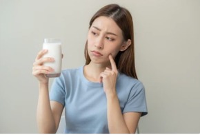 persona sujetando un vaso de leche fresca
